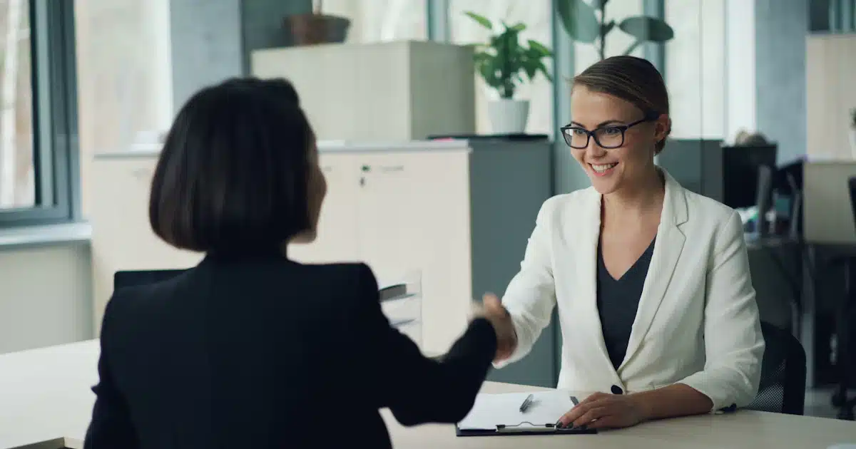 Recruteuse serrant la main d'une candidate lors d'un entretien de recrutement en entreprise