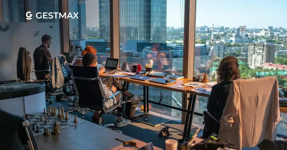 Collaborateurs dans un open space lumineux face à la ville, illustrant le choix d'un ATS PME ou grande entreprise