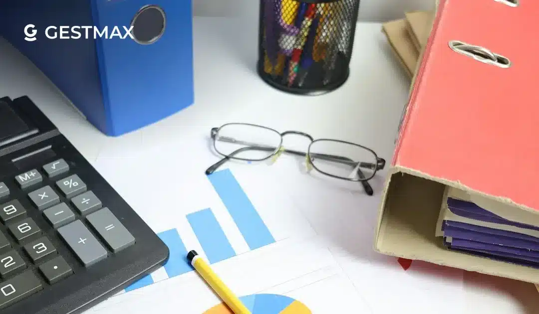 Calculatrice, graphiques et classeurs sur un bureau pour estimer le prix d'un logiciel ATS